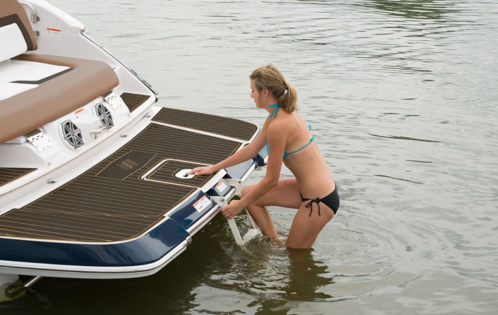 2 women climbing out of the water on to the back of the 2023 Four Winns Horizon 290