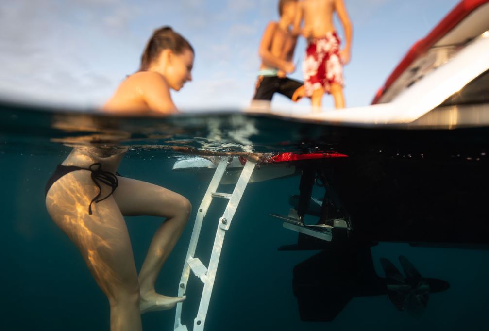women climbing out the water on to the back of the 2023 Four Winns HD2Surf