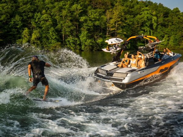 Malibu M220 with man surfing off the back of the boat